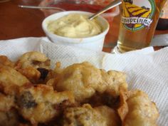 some food is on a napkin and next to a beer