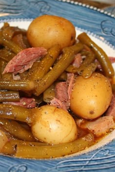 a blue and white plate topped with potatoes and green beans