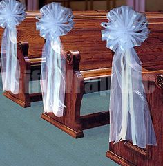 three wooden pews decorated with ribbons and bows