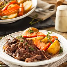 a white plate topped with roast, potatoes and carrots