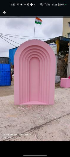 a large pink arch sitting on top of a cement ground