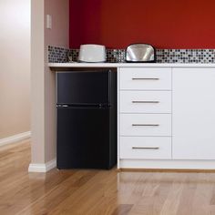 a black refrigerator freezer sitting inside of a kitchen