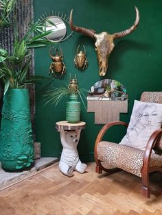 a living room with green walls and animal heads on the wall