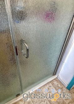 a glass shower door in a bathroom next to a tiled floor