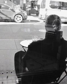 a man sitting in a chair looking out the window