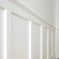 an empty hallway with white walls and wood flooring