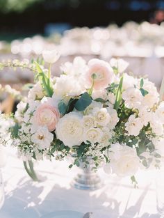 a vase filled with white and pink flowers on top of a table