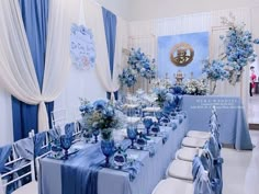 a table set up with blue and white decorations