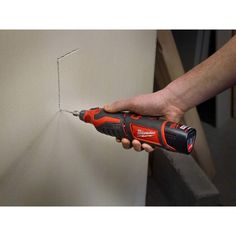 a person using a drill to fix a hole in the wall with a screwdriver