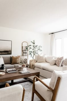 a living room filled with furniture and a wooden coffee table in front of a window