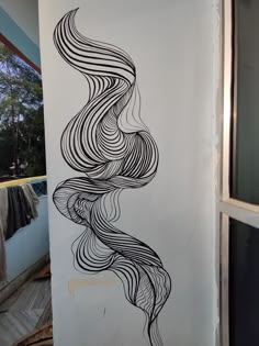 a drawing on the side of a wall in a room with clothes hanging up to dryer