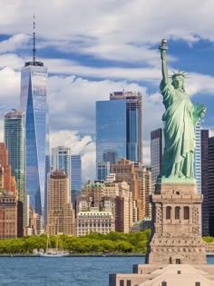 the statue of liberty stands in front of new york city's skyline and skyscrapers