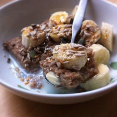 a bowl filled with bananas and granola on top of a table