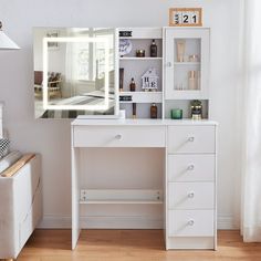 there is a white desk with drawers and a mirror on the wall in this room