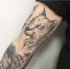 a man's arm with an animal and lion tattoo on the left side of his arm