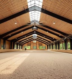 the inside of an indoor arena with lots of wood paneling and windows on the ceiling