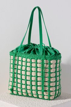 Accessorize with color this summer by carrying Shiraleah's Juanita Tote. Made from woven paper straw with a chic green cotton lining, this trendy bag will fit your favorite outfit perfectly. The drawstring closure ensures all your items are safely enclosed, while creating a unique silhouette that is sure to stand out from the crowd. Pair with other items from Shiraleah to complete your look! Casual Jute Bucket Bag For Spring, Casual Spring Jute Bucket Bag, Spring Bohemian Woven Bucket Bag, Casual Spring Basket Bucket Bag, Casual Spring Woven Bucket Bag, Spring Casual Woven Bucket Bag, Casual Woven Bucket Bag For Spring, Casual Woven Bucket Beach Bag, Casual Spring Bucket Bag With Braided Handles