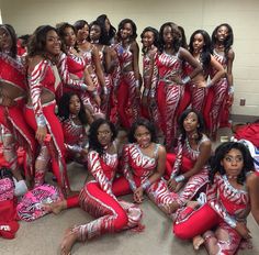 a group of women in red and silver outfits posing for a photo with each other