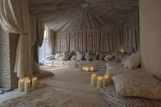 a living room filled with lots of pillows and candles