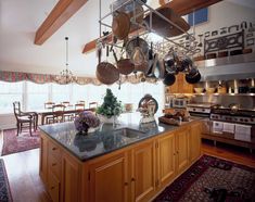 a kitchen filled with lots of pots and pans on top of a wooden island