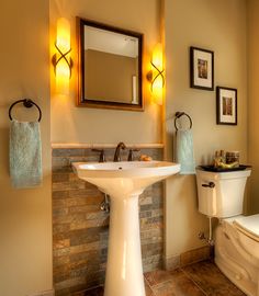 a bathroom with a toilet, sink and mirror in it's center piece is shown