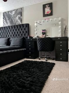 a black and white bedroom with a bed, desk, mirror and dresser in it