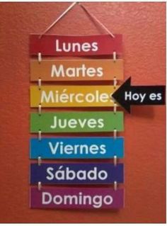 a sign hanging from the side of a wall with words written in spanish and english