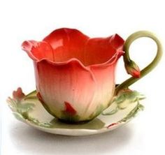 a tea cup and saucer sitting on top of a white plate with red flowers