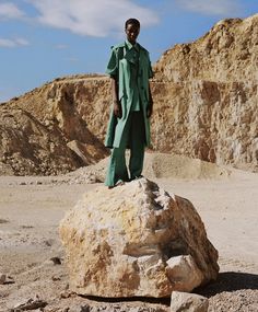 a man standing on top of a rock in the desert