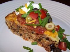 a slice of pizza on a white plate with green onions and tomatoes, sour cream