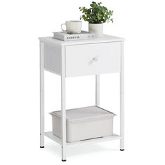 a white table with a plant on top and a basket under the shelf next to it