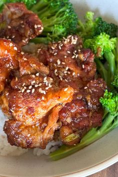 chicken and broccoli with sesame seeds on top of rice in a white bowl