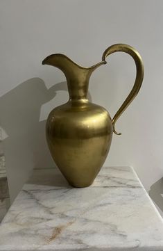 a gold vase sitting on top of a marble counter