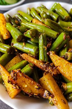 a white plate topped with green beans covered in seasoning