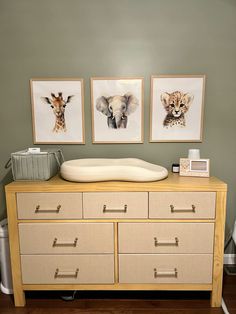 a dresser with drawers and pictures on the wall