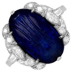 This exceptional Art Deco ring showcases a stunning natural Burmese carved cabochon sapphire, weighing approximately 8.64 carats. The center stone is elegantly complemented by an array of finely set diamonds, including single-cut, marquise, and baguette cuts, creating a harmonious design that enhances the sapphire's beauty. Crafted by hand in the 1920s, this antique ring is a true testament to the artistry of the era. The total approximate diamond weight is 0.60 carats, adding further brilliance Cabochon Sapphire Ring, Art Deco Jewelry Vintage, Sapphire Cocktail Ring, Jewels Rings, Antique Ring, Baguette Cut Diamond, Deco Ring, Antique Diamond, Sapphire Stone