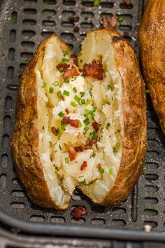 two baked potatoes sitting on top of a black grill grate next to each other