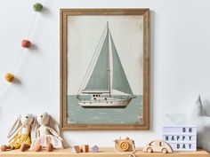 a wooden shelf topped with stuffed animals next to a framed sailboat painting on the wall