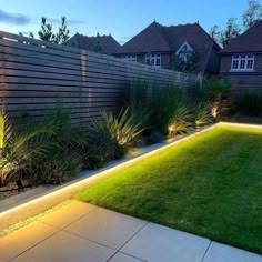 an image of a backyard that is lit up with lights and landscaping plants in it