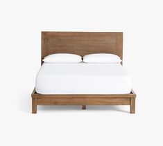 a bed with white sheets and pillows on it's headboard, against a white background