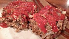 two pieces of meatloaf covered in ketchup on top of a plate