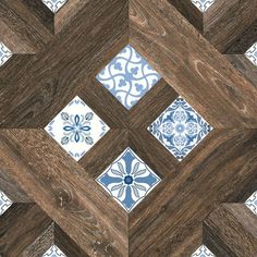 a wooden floor with blue and white tile designs on the wood grained planks