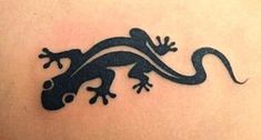 a lizard tattoo on the back of a woman's shoulder