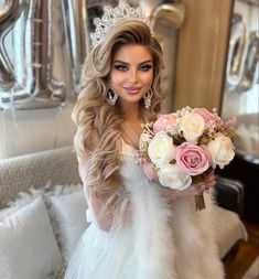 a woman wearing a tiara holding a bouquet of flowers