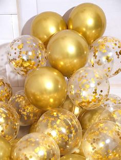 gold and white balloons are piled on top of each other