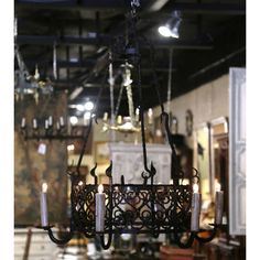 a chandelier with candles hanging from it's sides in a room filled with furniture