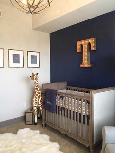 a baby's room with a giraffe in the corner and blue walls