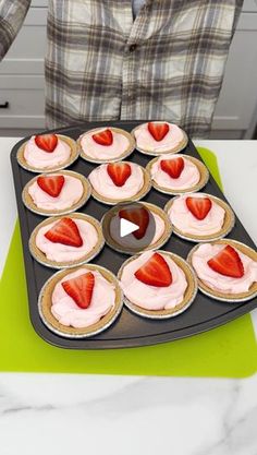 a person is holding a tray with cupcakes and strawberries on it in the shape of hearts