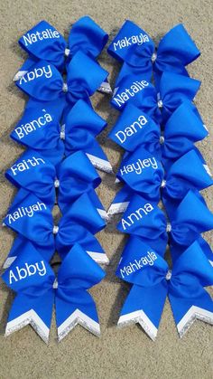 several blue bows with names on them sitting on the ground in front of a tweet