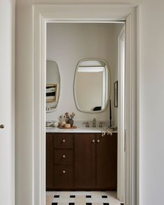 an open door leading to a bathroom with black and white checkered flooring